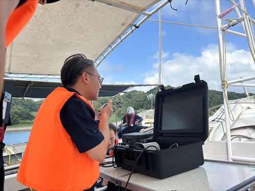 船上でモニターをとおし海底での調査を視察する大石知事_R